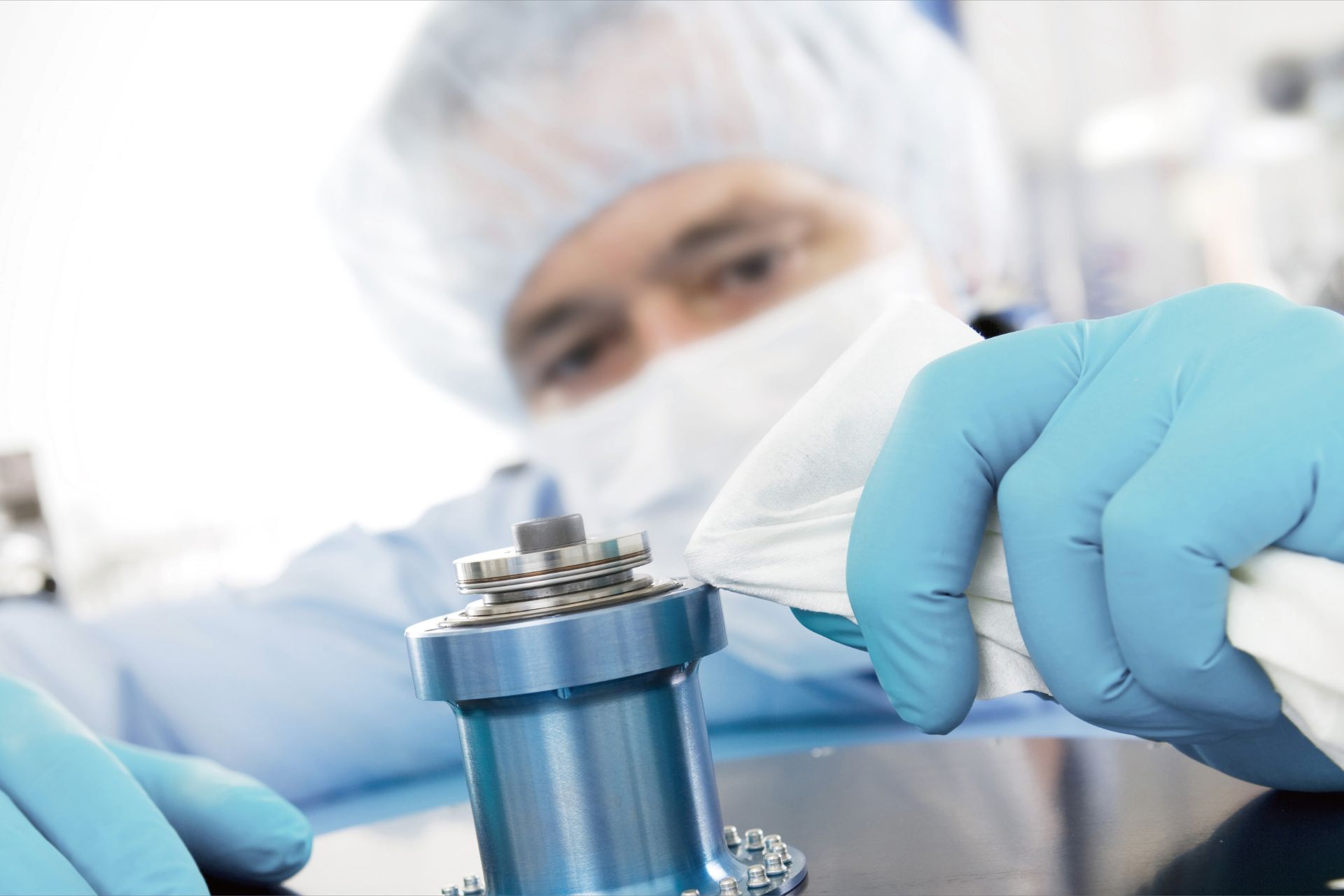 a worker is wiping machine with a cleanroom wipe.