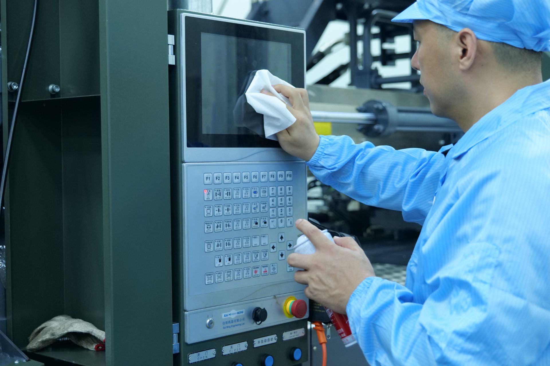 a worker using a multi purpose wipe to clean the screen of machine